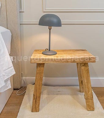 pormenor da mesa de cabeceira de um quarto com um candeeiro em cima 